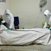 Nhân viên nhà tang lễ chuyển thi thể bệnh nhân tử vong do COVID-19 tại Cali, Colombia. (Ảnh: AFP/TTXVN)