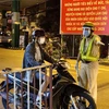 Lực lượng cảnh sát giao thông hướng dẫn người dân dừng xe khai báo y tế trên đường Lê Quang Định (phường 1, quận Gò Vấp, Tp. Hồ Chí Minh ngyaf 31/5. (Ảnh: Hồng Giang/TTXVN)