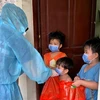 Các thanh niên tình nguyện trao quà Tết thiếu nhi cho các trẻ em trong khu cách ly tại Thuận An (Bình Dương). (Ảnh: TTXVN phát)