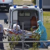 Nhân viên y tế chuyển bệnh nhân COVID-19 tới bệnh viện ở Moskva, Nga, ngày 16/7/2021. (Ảnh: THX/TTXVN)