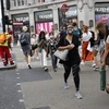 Người dân đeo khẩu trang phòng lây nhiễm COVID-19 khi di chuyển trên đường phố tại London, Anh ngày 24/7/2020. (Ảnh: AFP/TTXVN)
