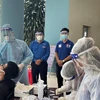 Nhân viên y tế lấy mẫu test nhanh "quét" F0 trên địa bàn thành phố Dĩ An (Bình Dương). (Ảnh: TTXVN phát)