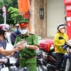 Lực lượng chức năng kiểm tra người dân thực hiện khai báo thông tin di biến động trên đường Võ Thị Sáu, quận 3, Thành phố Hồ Chí Minh. (Ảnh: Thanh Vũ/TTXVN)