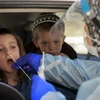 Nhân viên y tế lấy mẫu xét nghiệm COVID-19 cho một em nhỏ tại Jerusalem ngày 29/7/2021. (Ảnh: AFP/TTXVN)