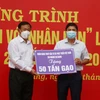 Ông Nguyễn Tiếc Hùng, Chủ tịch Ủy ban Mặt trận Tổ quốc Việt Nam tỉnh An Giang (trái), tiếp nhận bằng tượng trưng hỗ trợ từ các nhà hảo tâm. (Ảnh: Công Mạo/TTXVN)