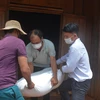 UBND xã Ea Kiết, huyện Cư M’Gar chở gạo cứu đói đến trao tận tay cho gia đình anh Bùi Quốc Thọ (giữa), hộ gặp khó khăn do dịch COVID-19. (Ảnh: Hoài Thu/TTXVN)
