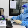 Các bác sỹ Bệnh viện Đa khoa tư nhân Hùng Vương làm xét nghiệm trên hệ xét nghiệm SARS-CoV-2. (Ảnh: Trung Kiên/TTXVN)