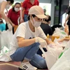 Ca sỹ Uyên Linh đóng gói nhu yếu phẩm để trao cho người dân gặp khó khăn do COVID-19. (Nguồn: tuoitre.vn)