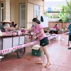 Người dân xã Nghi Phú, thành phố Vinh giữ khoảng cách, thực hiện nghiêm khuyến cáo 5K của Bộ Y tế khi đến mua lương thực, thực phẩm tại điểm bán hàng lưu động trên địa bàn. (Ảnh: Tá Chuyên/TTXVN)