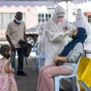 Nhân viên y tế lấy mẫu xét nghiệm COVID-19 cho người dân tại Subang, bang Selangor, Malaysia. (Ảnh: THX/TTXVN)