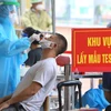 Nhân viên y tế mặc đồ bảo hộ thực hiện xét nghiệm COVID-19 cho người dân tại Hà Nội. (Ảnh: Hoàng Hiếu/TTXVN)
