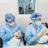 Nhân viên y tế Bệnh viện Nhi Đồng TP. Hồ Chí Minh chăm sóc trẻ có cha, mẹ là F0. (Nguồn: baodantoc.vn)
