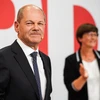 Lãnh đạo đảng Dân chủ Xã hội Đức (SPD) Olaf Scholz (trái) khi kết quả thăm dò sau bầu cử được công bố, ở Berlin, ngày 26/9/2021. (Ảnh: THX/TTXVN)