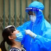 Nhân viên y tế lấy mẫu xét nghiệm COVID-19 cho người dân tại Hà Nội. (Ảnh: Tuấn Anh/TTXVN)