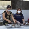 Chị Lê Thị Thanh Hương (phải) tổ chức nấu và cung cấp miễn phí hơn 90.000 suất ăn cho lực lượng tham gia chống dịch, người trong khu phong tỏa, cách ly. (Ảnh: Nhựt An/TTXVN)