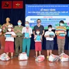 Đại diện các nhà hảo tâm trao tặng máy tính bảng và quà cho một số học sinh người Khmer và Chăm có hoàn cảnh khó khăn. (Ảnh: Xuân Khu/TTXVN)