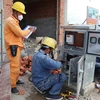 Nhân viên điện lực lắp điện kế cho người dân Khu tái định cư Lộc An-Bình Sơn. (Ảnh: Công Phong/TTXVN)
