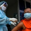 Nhân viên y tế tiêm vaccine ngừa COVID-19 cho nhà sư tại Phnom Penh, Campuchia. Trẻ em dưới 5 tuổi chưa được tiêm vaccine. (Ảnh: AFP/TTXVN)