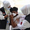 Nhân viên y tế tiêm vaccine phòng COVID-19 cho học sinh tại Banda Aceh, Indonesia, ngày 9/11/2021. (Ảnh: AFP/TTXVN)