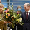 Ông Olaf Scholz tặng hoa cho Thủ tướng sắp mãn nhiệm Angela Merkel trước cuộc họp nội các ở Berlin, Đức, ngày 24/11/2021. (Ảnh: AFP/TXVN)