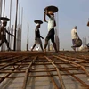 Các công nhân làm việc tại công trường xây dựng một khu dân cư phức hợp ở ngoại ô Kolkata, Ấn Độ. (Ảnh: Reuters)