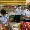 Các kiểm soát viên thị trường của Cục Quản lý thị trường TP Hồ Chí Minh kiểm tra nhiều nội dung tại cửa hàng Bách Hóa Xanh. (Ảnh: Thành Chung/TTXVN)
