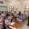 Giáo viên trên lớp mở laptop để học sinh F0, F1 đang cách ly tại nhà có thể cùng học với các bạn ở lớp. (Ảnh: Đức Hạnh/TTXVN)