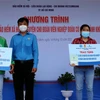 Lãnh đạo Liên đoàn Lao động quận Tân Phú, TP Hồ Chí Minh trao sổ bảo hiểm cho đoàn viên nghiệp đoàn có hoàn cảnh khó khăn. (Ảnh: Thanh Vũ/TTXVN)