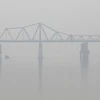 Sương mù dày đặc cùng bụi bẩn ô nhiễm không khí tại khu vực cầu Long Biên. (Ảnh: Thành Đạt/TTXVN)