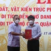 Ông Trần Đức Nghị, Trưởng gia tộc Trần Đức, trao sổ đỏ 1.800m2 đất cho đại diện lãnh đạo thị xã Hoài Nhơn. (Ảnh: Phạm Kha/TTXVN)