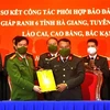 Lãnh đạo Công an tỉnh Hà Giang bàn giao đơn vị thường trực năm 2022 cho lãnh đạo Công an tỉnh Tuyên Quang. (Ảnh: Kim Tiến/TTXVN)