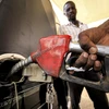 Bơm xăng cho phương tiện tại một trạm xăng ở Khartoum, Sudan. (Ảnh: AFP/TTXVN)