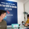 Nhân viên y tế hỗ trợ cho người dân đến tư vấn tại Trung tâm y tế quận Tân Bình, Thành phố Hồ Chí Minh. (Ảnh: T.G/Vietnam+)