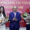 Chủ tịch nước Nguyễn Xuân Phúc tặng chân dung Chủ tịch Hồ Chí Minh cho các tác giả trẻ lần thứ nhất. (Ảnh: Thống Nhất/TTXVN)
