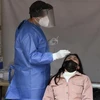 Nhân viên y tế lấy mẫu xét nghiệm COVID-19 cho người dân tại Mexico City, Mexico. (Ảnh: AFP/TTXVN)