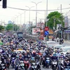 Người dân từ miền Tây về Thành phố Hồ Chí Minh rất đông, khiến Quốc lộ 1 đoạn qua cầu Bình Điền di chuyển khó khăn. (Ảnh: Tiến Lực/TTXVN)