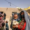 Phụ nữ và trẻ em những người phải rời bỏ nhà cửa do chiến tranh, đợi khám bệnh tại một phòng khám ở làng Yarmuhamad, tỉnh Helmand, Afghanistan, ngày 28/3/2021. (Ảnh: AFP/TTXVN)