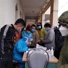 Công nhân chen nhau lấy mẫu xét nghiệm tại Trạm y tế phường Bình Minh, thị xã Nghi Sơn (Thanh Hóa). (Ảnh: Nguyễn Nam/TTXVN)