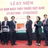 Chủ tịch Quốc hội Vương Đình Huệ tặng quà chúc mừng Bệnh viện Hữu nghị Việt Đức. (Ảnh: Doãn Tấn/TTXVN)