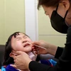 Nhân viên y tế lấy mẫu xét nghiệm COVID-19 cho một em nhỏ tại Seoul, Hàn Quốc ngày 24/2/2022. (Ảnh: Yonhap/TTXVN)