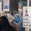 Nhân viên y tế lấy mẫu xét nghiệm COVID-19 cho người dân tại Seoul, Hàn Quốc, ngày 4/3/2022. (Ảnh: AFP/TTXVN)