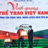Thứ trưởng Bộ VH, TT và DL Hoàng Đạo Cương trao Huân chương Lao động hạng Nhì, Ba cho vận động viên Lê Văn Công và huấn luyện viên Lê Quang Thái. (Ảnh: Tuấn Anh/TTXVN)