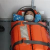 Thuyền viên Ngô Tấn Lộc bị nạn trên biển được cấp cứu trên tàu SAR 421 và đưa về bờ. (Ảnh: TTXVN phát)