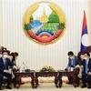 Tổng Bí thư - Chủ tịch nước Lào Thongloun Sisulith tiếp Bí thư Thành ủy Hà Nội Đinh Tiến Dũng. (Ảnh: Phạm Kiên/TTXVN)