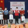 Đại diện Hội Chữ thập đỏ Việt Nam và chính quyền địa phương trao nhu yếu phẩm cho các hộ dân. (Ảnh: TTXVN phát)