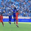 Tiền đạo đội trưởng U23 Lào Ekkamai (20) tranh chấp bóng bổng với hậu vệ Syahrul bin Sazaly (13, U23 Singapore). (Ảnh: Tuấn Anh/TTXVN)