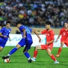 Weerathep Pomphun (18) của U23 Thái Lan nỗ lực đi bóng trước sự truy cản của cầu thủ U23 Singapore. (Ảnh: Tuấn Anh/TTXVN)