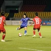Cầu thủ Nutwadee Pram-Nak của đội tuyển nữ Thái Lan tung cú sút bóng khi có đến 4 cầu thủ đội tuyển nữ Lào bủa vây. (Ảnh: Anh Tuấn/TTXVN)