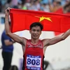 VĐV Nguyễn Văn Lai vui mừng chiếc Huy chương Vàng 10.000m nam tại SEA Games 31. (Ảnh: Quốc Khánh/TTXVN)