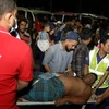 Các nhân viên cứu hộ và dân thường khiêng một nạn nhân bị thương tới bệnh viện ở Chittagong, Bangladesh, sau khi đám cháy lớn bùng phát tại một kho cảng container địa phương. (Nguồn: AFP)